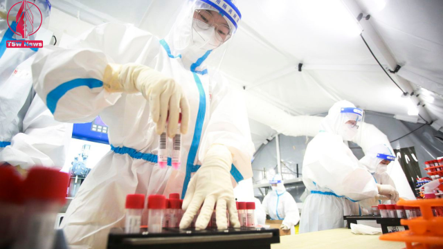 Medical workers examine samples from local residents to be tested for Covid-19 at a mobile test lab in Yangzhou, China