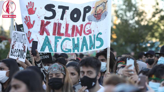 Protesters hold a sign that reads “stop killing Afghans” at a demonstration in Canada